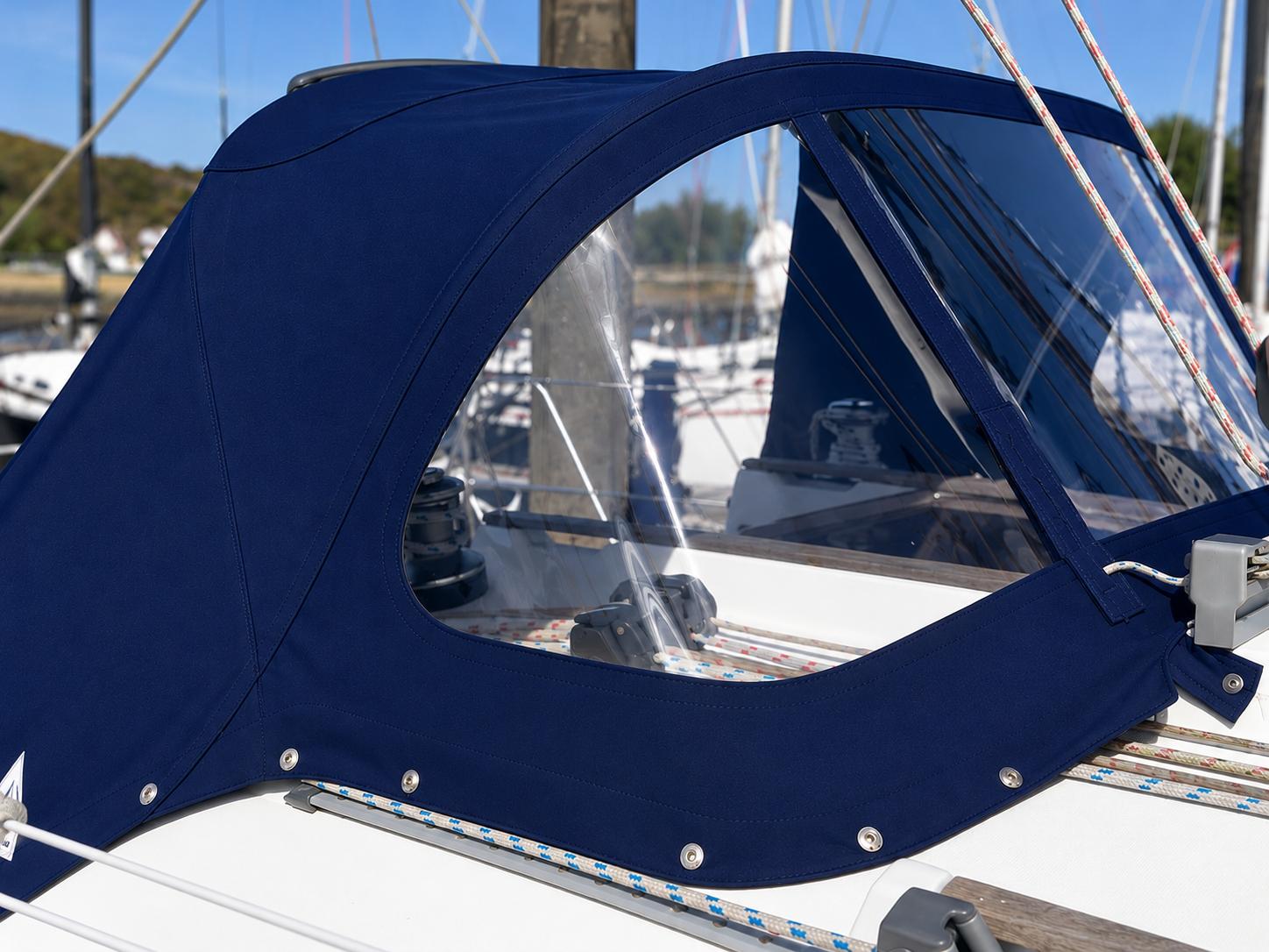 Navy blue marine canvas sprayhood with large clear windows and press-stud fixings, made by Boatshed Sailmakers and fitted over a yacht’s cockpit