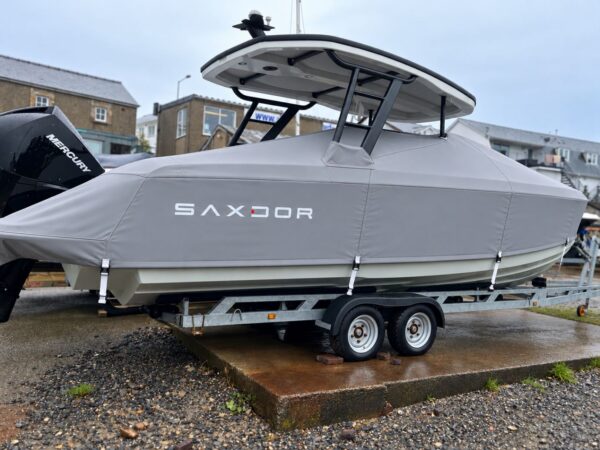 Saxdor 270 on its trailer with a grey full winter cover fitted under the T-top, lettered SAXDOR along the side and strapped to the hull
